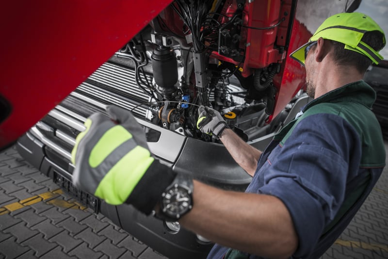 guy_performing_truck_engine_maintenance
